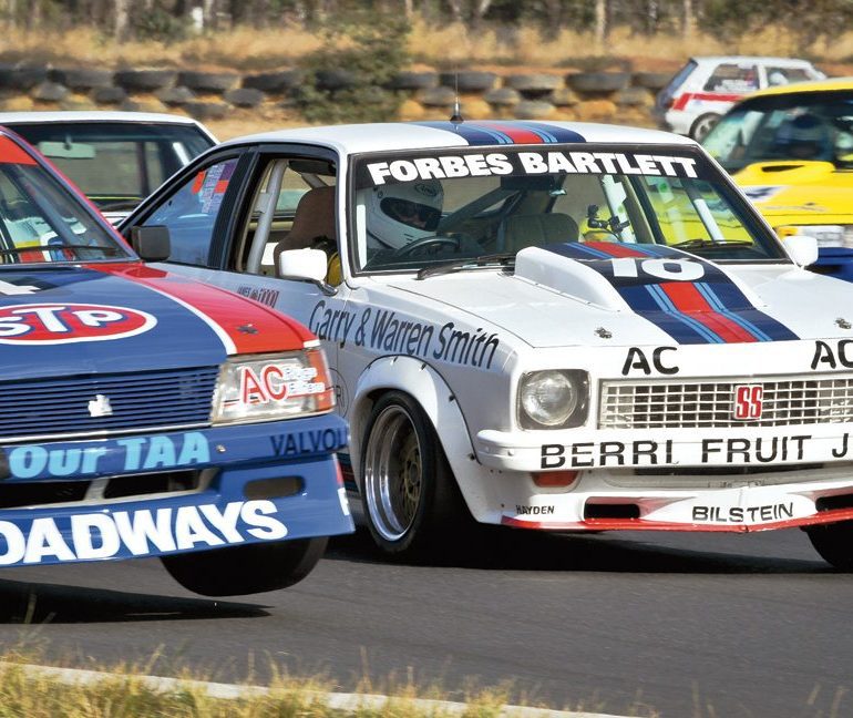 Edward Singleton (Holden Commodore) lifts a wheel on the outside line as Shaun Tunny looks for a way through in his Holden Torana A9X. Photo: Ian Welsh