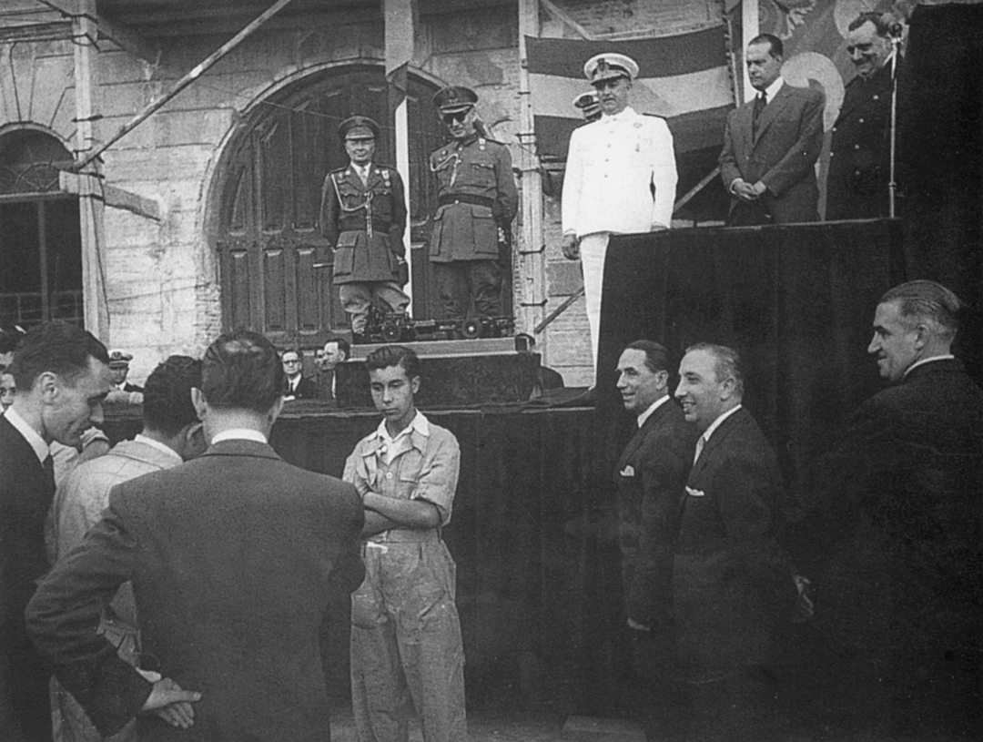 Spanish dictator Generalissimo Franco (white suit) visits the E.N.A.S.A. factory. Pegaso director Wifredo Ricart stands directly below him.