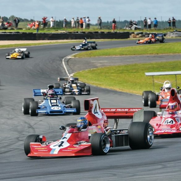 As usual, veteran Ken Smith is out front of the F5000 field in his Lola T430, chased by the Lola T400 of Mark Dwyer and the rest of the field. Photo: Ian Welsh