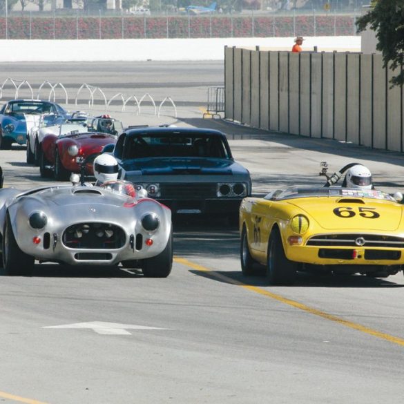 Tom Sakai in his 1965 Sunbeam Tiger (#65) leads the field under the bridge during Saturday morning. Photo: Craig R. Edwards