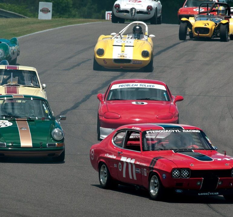 Ira Schoen’s Ford Capri leads George Calfo’s Porsche 911S and a host of others into the downhill sweeper. Photo: Chuck Andersen