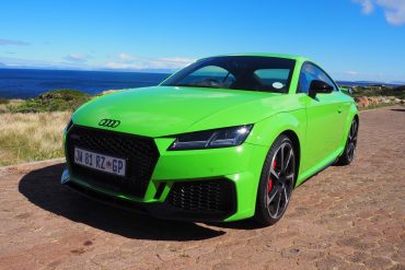 Green 2022 Audi TT RS on cobblestone street near ocean