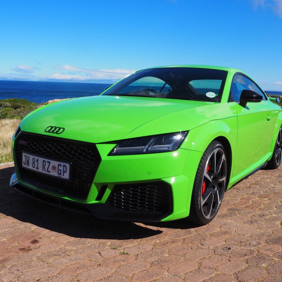 Green 2022 Audi TT RS on cobblestone street near ocean