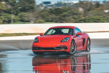 Red Porsche 718 Cayman GTS sliding on a wet track