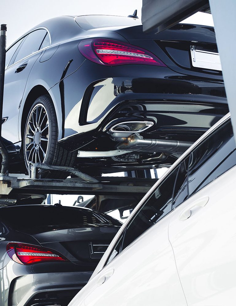 Mercedes Benz vehicles being transported on a car carrier truck.