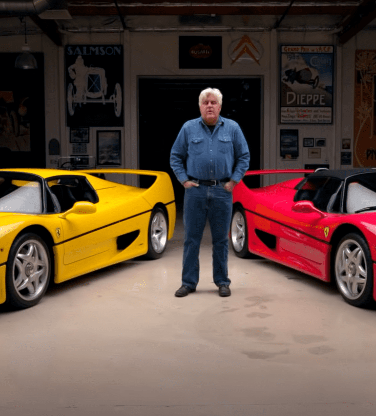 Jay Leno standing in front of yellow and red Ferrari F50