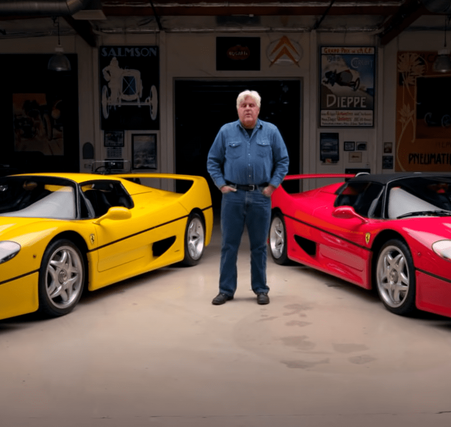 Jay Leno standing in front of yellow and red Ferrari F50