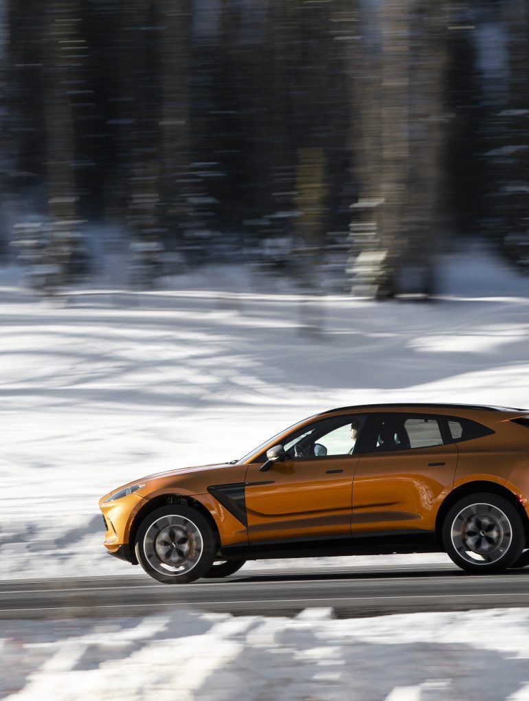 2021 Aston Martin DBX driving through snowy scenery