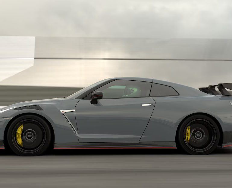 A rolling shot of a grey Nissan GT-R showing its side profile.