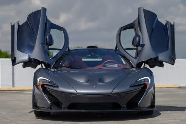 Front view of a grey 2015 McLaren P1 with butterfly doors open