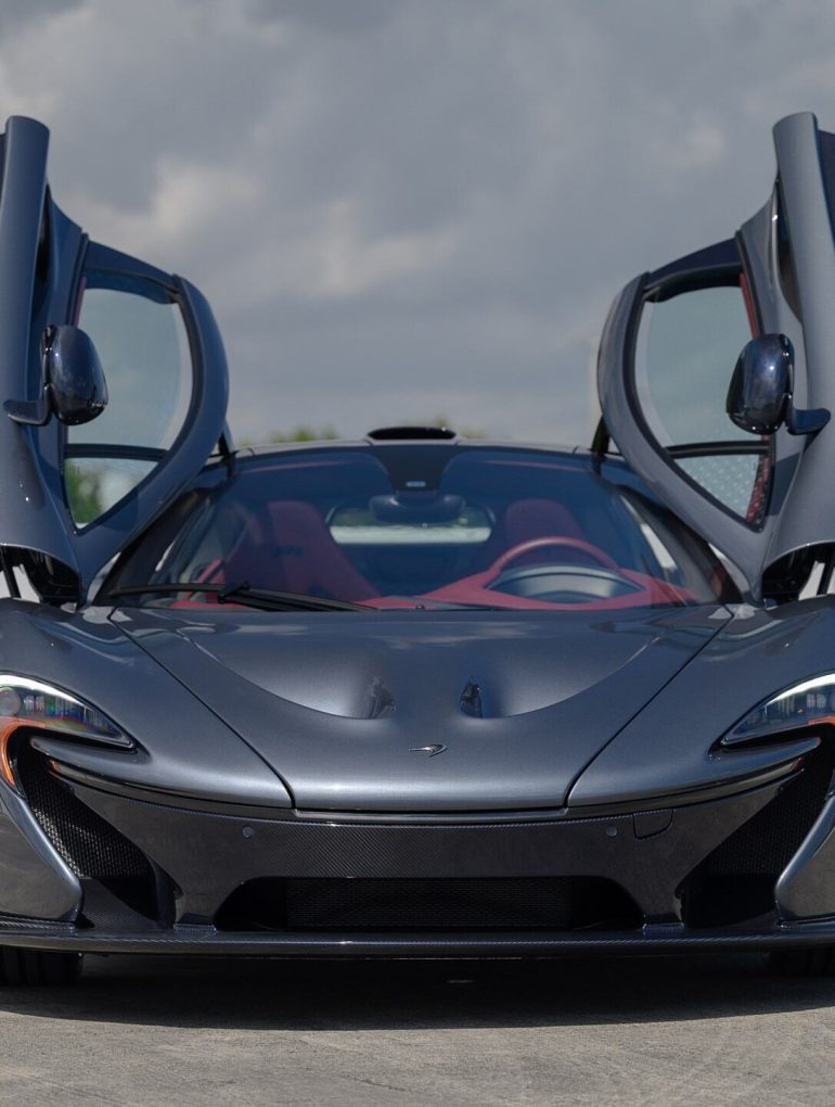 Front view of a grey 2015 McLaren P1 with butterfly doors open