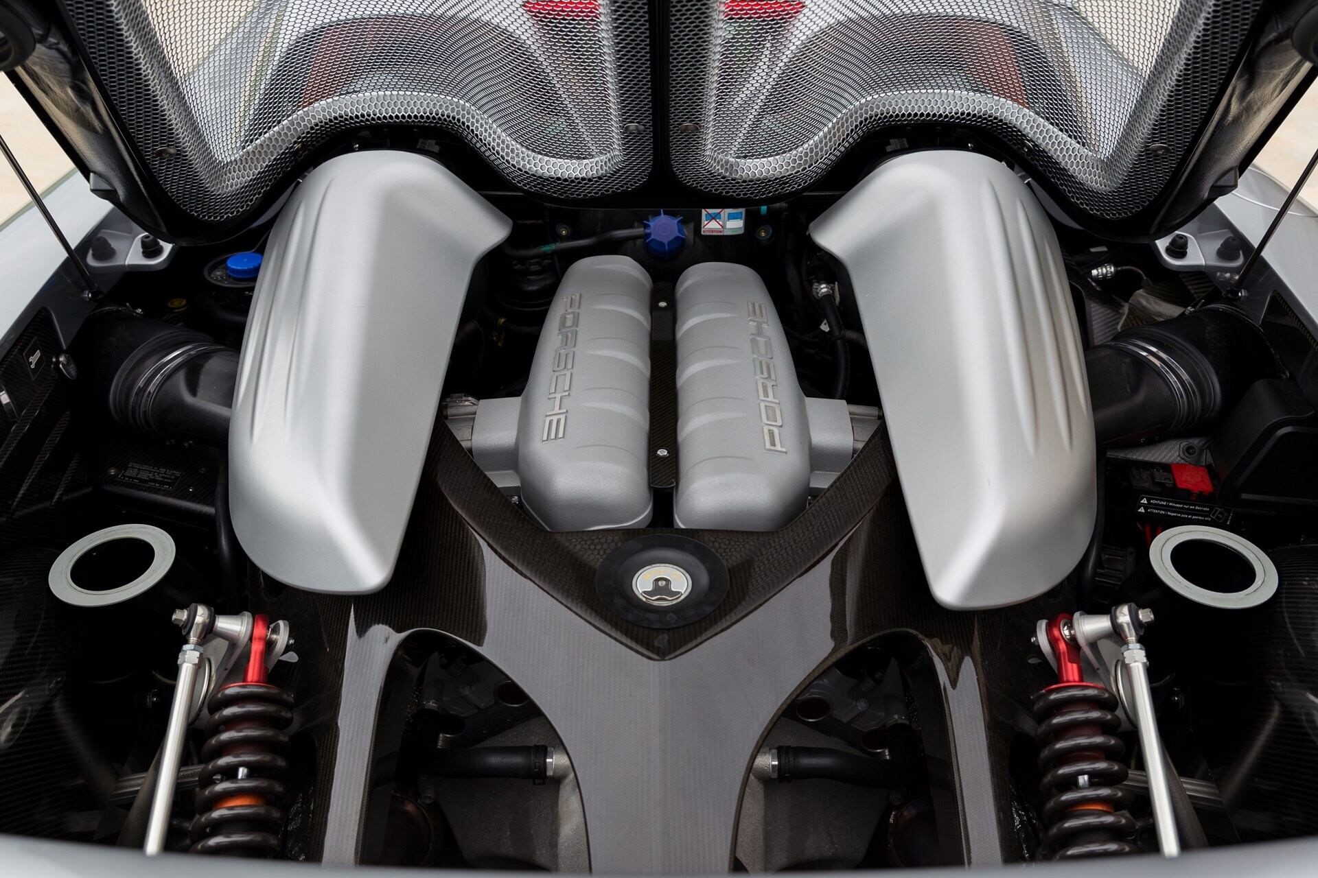 A peek at the engine of a silver 2005 Porsche Carrera GT